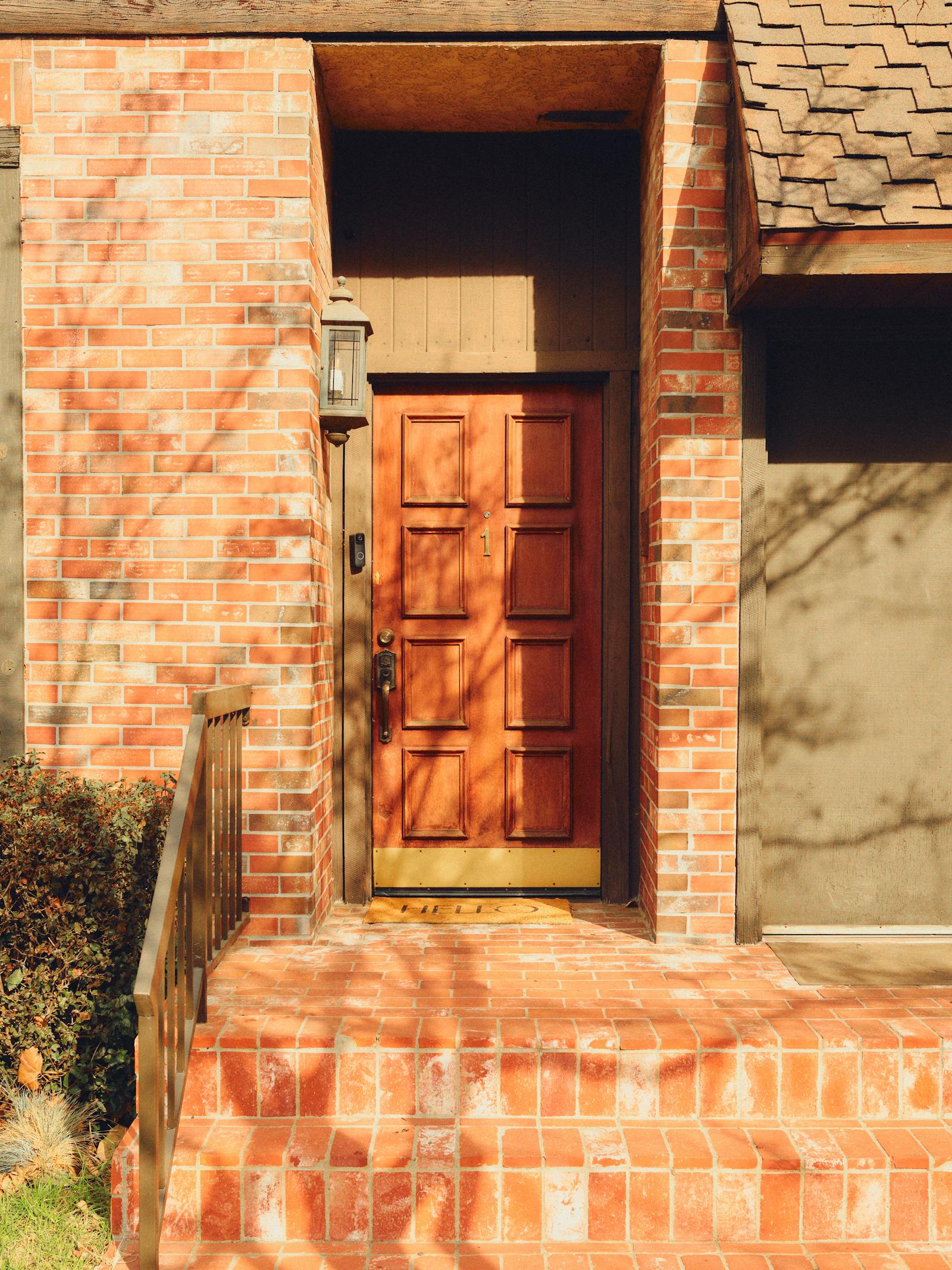 Wood entry door on a brick West Texas home
